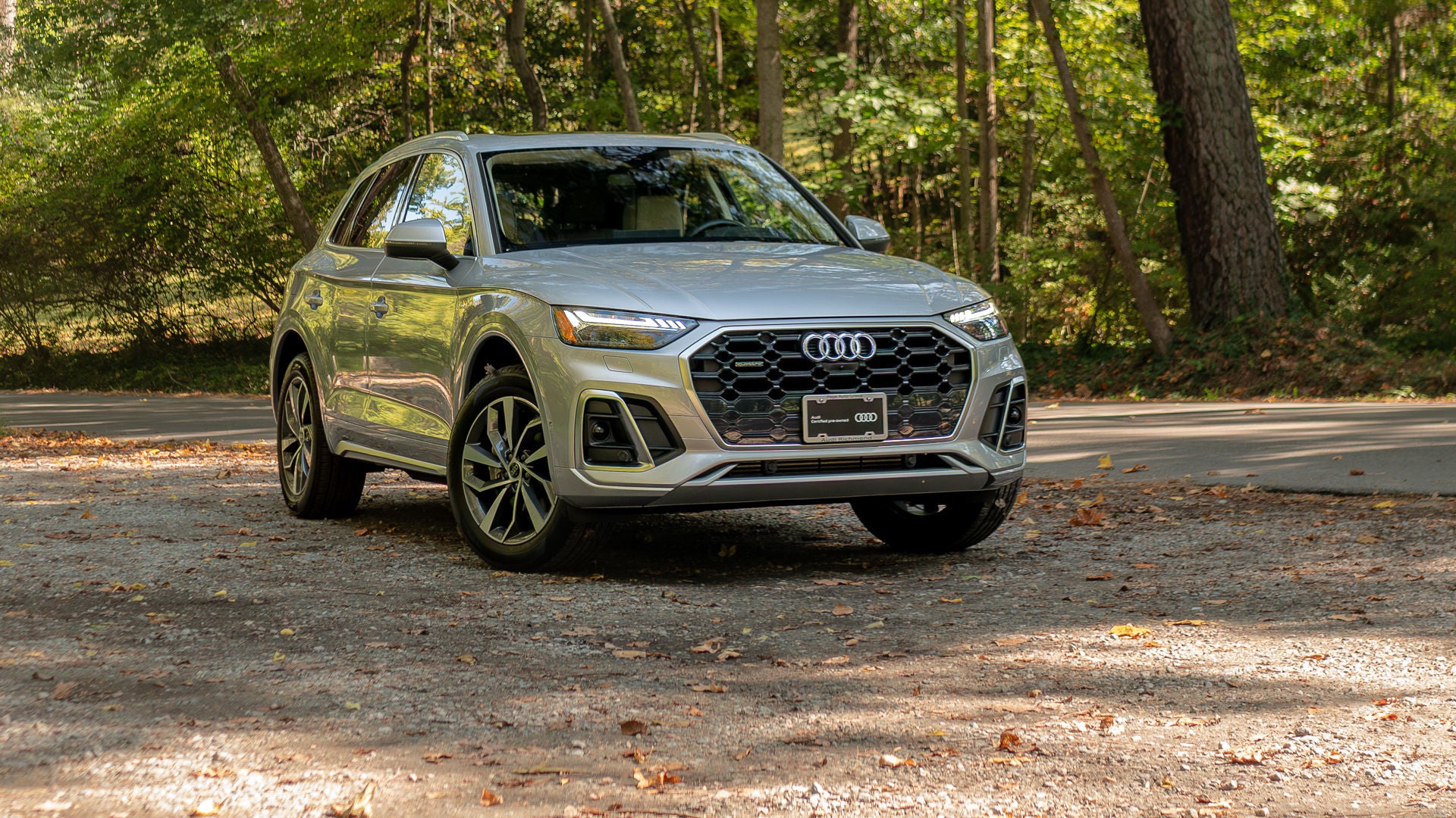 Rear view of a green Audi accelerating down the road. 